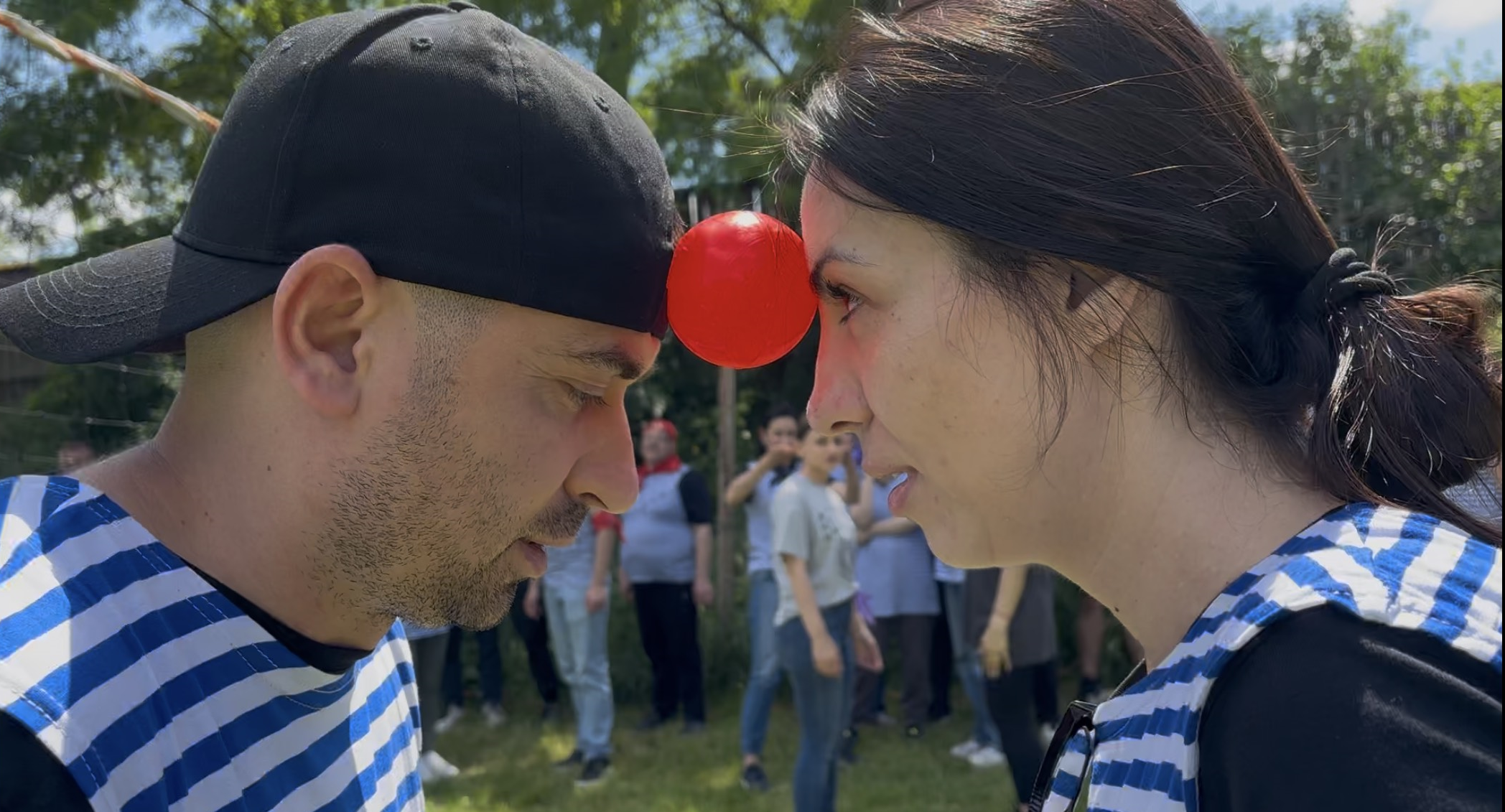 Două persoane transportând un obiect între frunți fără să-l scape activitate de teambuilding pentru încredere și coordonare